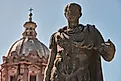 Bronze statue of emperor Julius Caesar, the dome of Saints Luca and Martina Church in the background. Image credit: Di Gregorio Giulio/Shutterstock.com