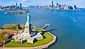 Aerial view of the Statue of Liberty, Ellis Island, and Lower Manhattan Skyline from New York Harbor near Liberty State Park in New Jersey.