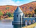 Saville Dam with colorful trees covering hills in the background, Barkhamsted, Connecticut.