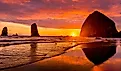 Colorful sunset, birds, Haystack Rock sea stacks, Canon Beach, Clatsop County, Oregon.