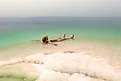 Woman relaxing in salty water of the Dead Sea. Via Shutterstock / xamnesiacx84