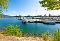 The marina and city beach area of downtown Sandpoint, Idaho, with boats filling the docks on Lake Pend Oreille on a summer day in the Idaho panhandle.