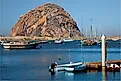  View of boats and Morro Rock along the coast of Morro Bay in California.