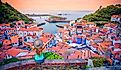 Woman enjoying view of Cudillero village in Asturias, at sunset- Spain.