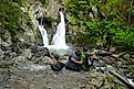 A couple sits together in front of the majestic Bash Bish Falls, Massachusetts. Image credit: 26ShadesOfGreen / Shutterstock.com.