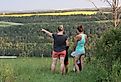 A woman pointing towards the Red Deer river valley, near Lacombe, Alberta. Image credit Carol Provins via Shutterstock