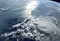 A stunning view of Earth from space, showcasing the vastness of the ocean and the intricate patterns of clouds illuminated by the sun.