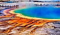 Grand Prismatice Spring in Yellowstone National Park with tourists viewing the spectacular natural scene