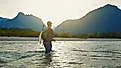 A man in outdoor gear fly-fishes