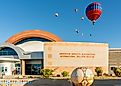 Colorful hot air balloons floating above the Anderson Abruzzo Albuquerque International Balloon Museum. Editorial credit: Steve Lagreca / Shutterstock.com.