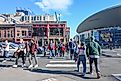 Pedestrians in Nashville, Tennessee, with Nashville Arena in the background.