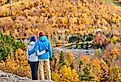 Couple hiking at Artist's Bluff in autumn. Fall colours in Franconia Notch State Park. White Mountain National Forest, New Hampshire, USA