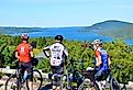 Bicyclists stop on route around Canandaigua Lake, New York with mountains in the background.