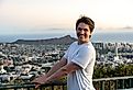 Student smiling with the cityscape of Honolulu in the background.