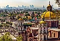 Mexico. Basilica of Our Lady of Guadalupe. Cupolas of the old basilica and cityscape of Mexico City. Image credit WitR via Shutterstock