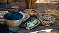 Ancient valuables in various bowls and containers on a wooden table.