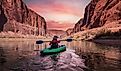 Glen Canyon, Arizona: Adventurous woman on a kayak paddling in the Colorado River during sunrise.