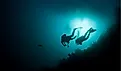 Divers approaching deep ocean depths