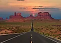 A highway running toward the buttes of Monument Valley near the Arizona-Utah line.