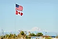 US and Canadian Flag. US and Canadian Flags fly in Point Roberts, Washington State. (Credit: Max Lindenthaler / Shutterstock)