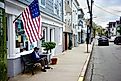 An elderly man seated under an old American flag on Main Street in Stonington, Connecticut. Editorial credit: Joe Tabacca / Shutterstock.com