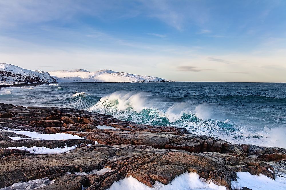 Spring blooming trees, pink blossoms of cherry river reflection in Which Countries Have A Coastline On The Barents Sea? - WorldAtlas.com