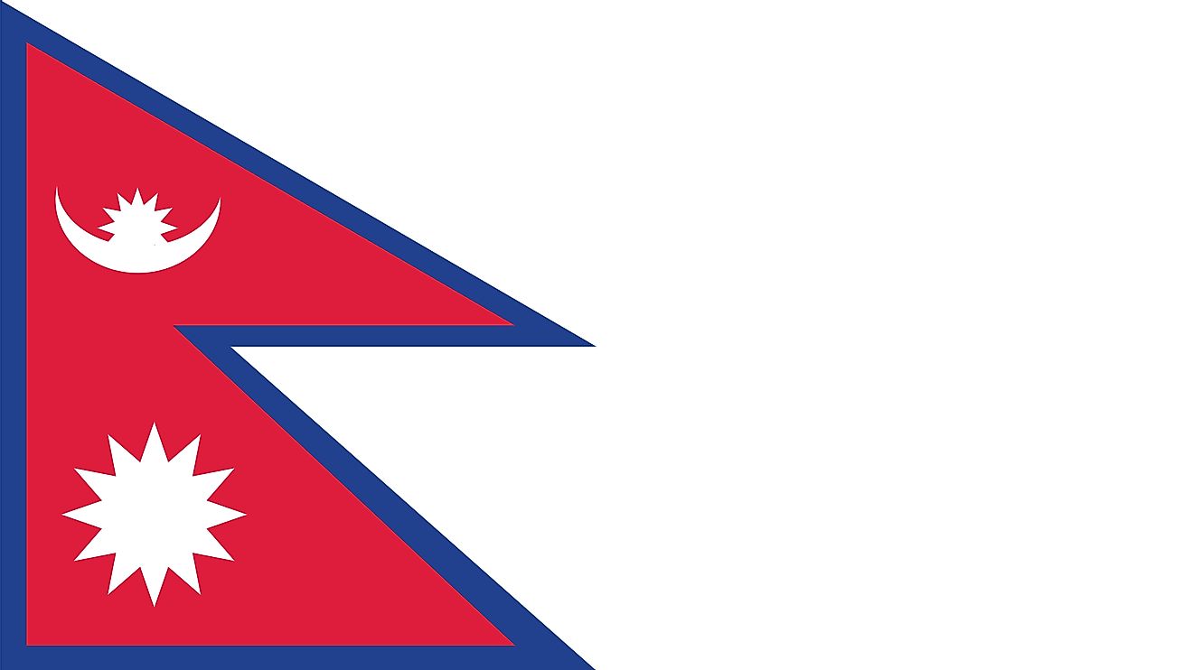 The flag of Nepal consists of a crimson red background with a blue border around the unique shape of two overlapping right triangles. The smaller, upper triangle bears a white stylized moon and the larger, lower triangle displays a white 12-pointed sun.