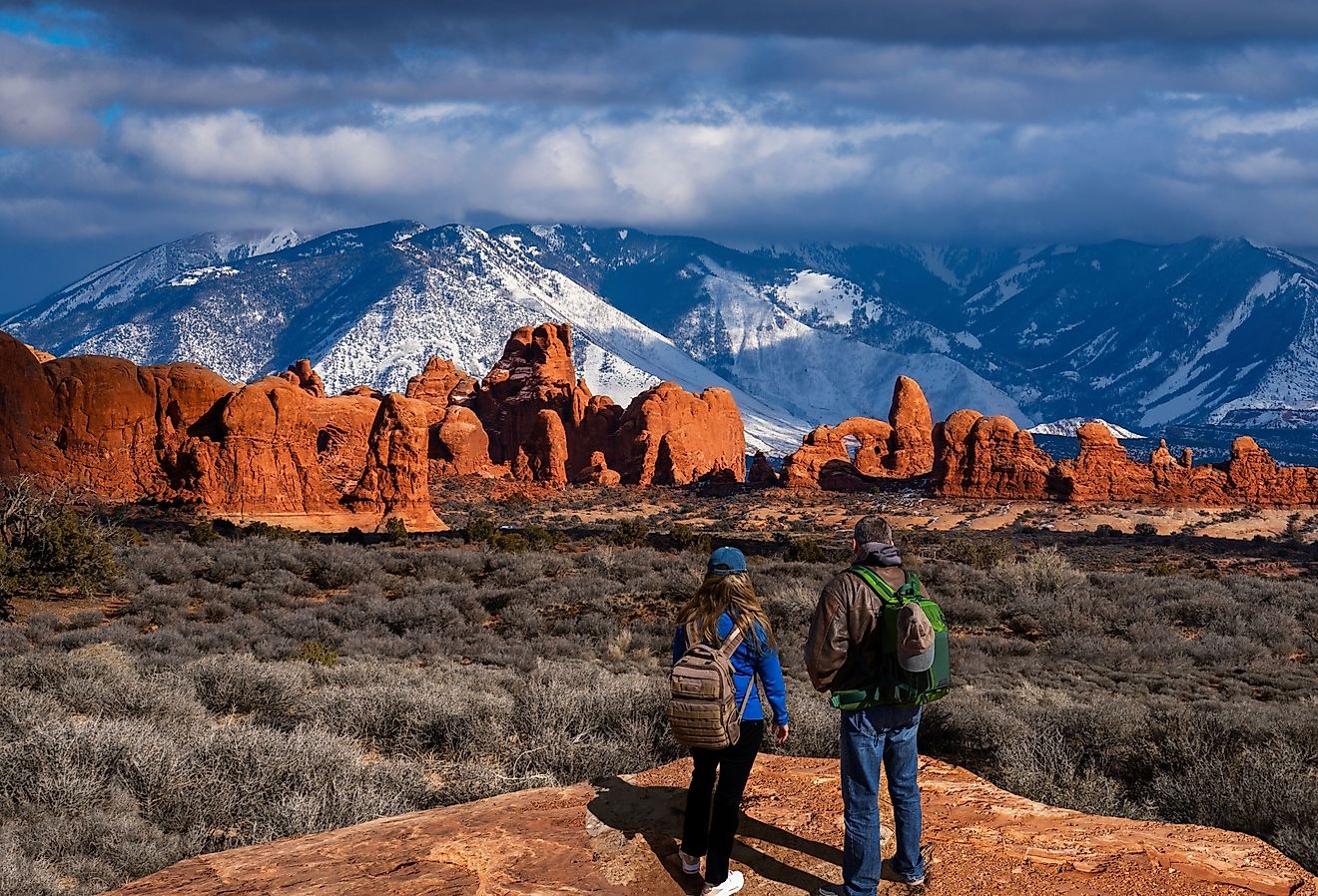 Couple in awe of La Sal Mountains at Arches National Park in Moab, Utah.
