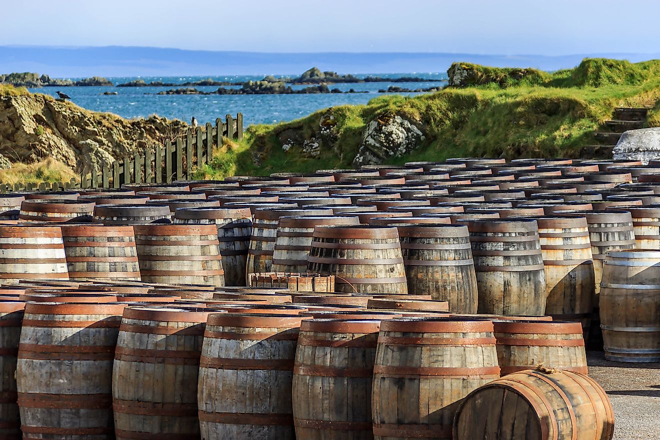 Scotch whisky barrels lined up seaside on the Island of Islay, Scotland UK. Image credit:  Rebecca Schochenmaier/Shutterstock.com