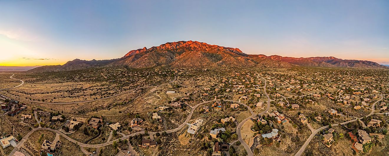 Sandia mountains in Albuquerque, New Mexico at sunset, glowing pink.