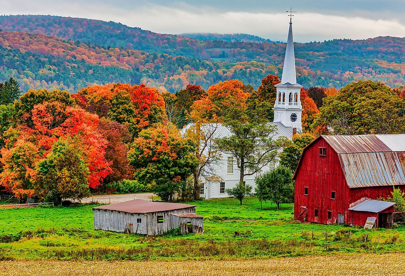 Red barn and church next to a harvested cornfield in Woodstock, Vermont. Image credit MindStorm via Shutterstock