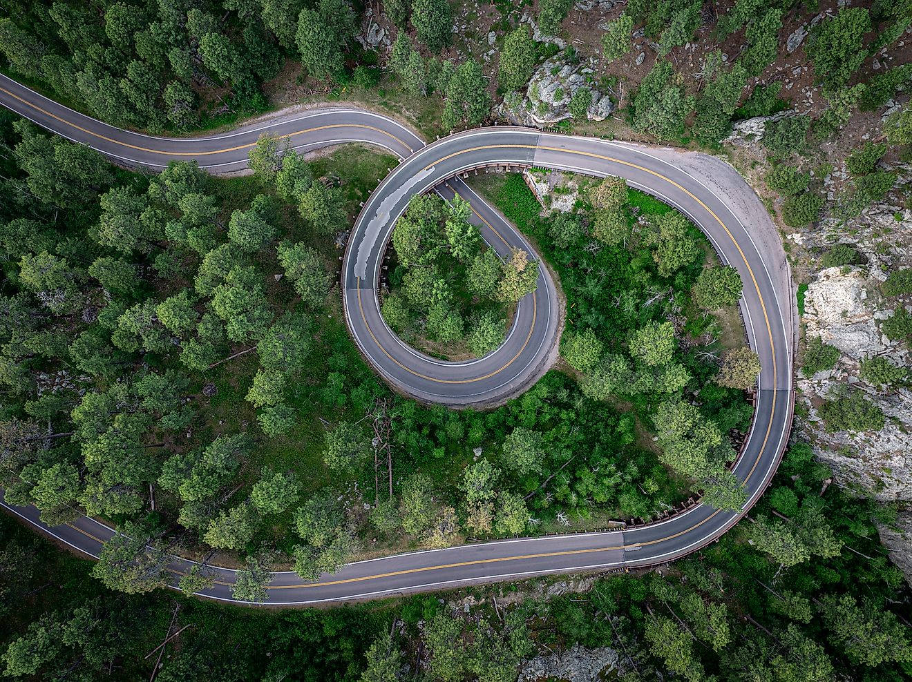 Aerial view of Norbeck Scenic Byway winding through forested hills and rugged terrain in the Black Hills of South Dakota