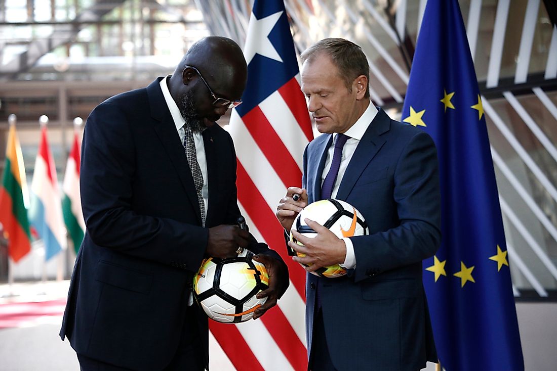 George Weah, left, and EU Council President Donald Tusk sign footballs. Editorial credit: Alexandros Michailidis / Shutterstock.com.