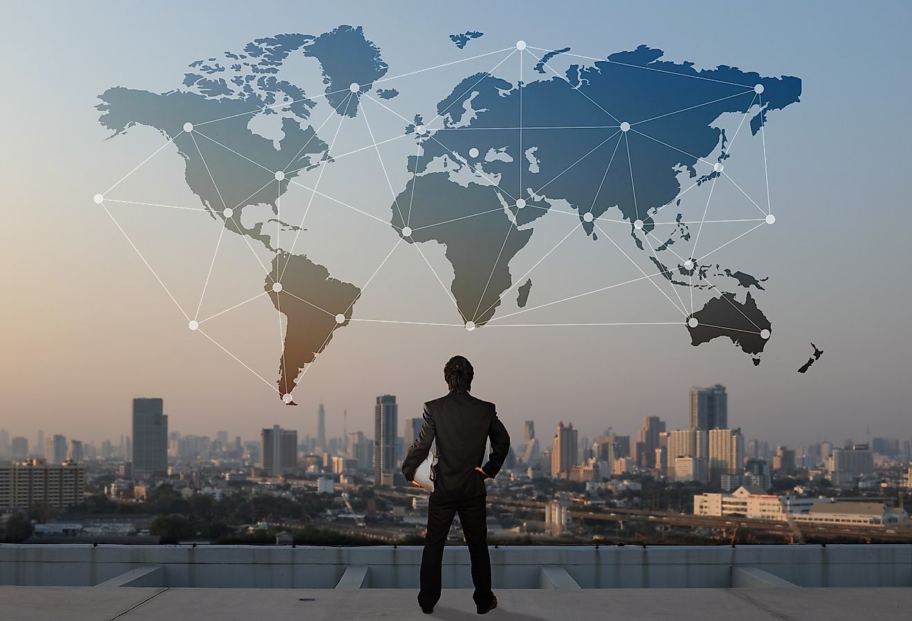 Businessman standing on roof top of skyscraper, global economic concept.