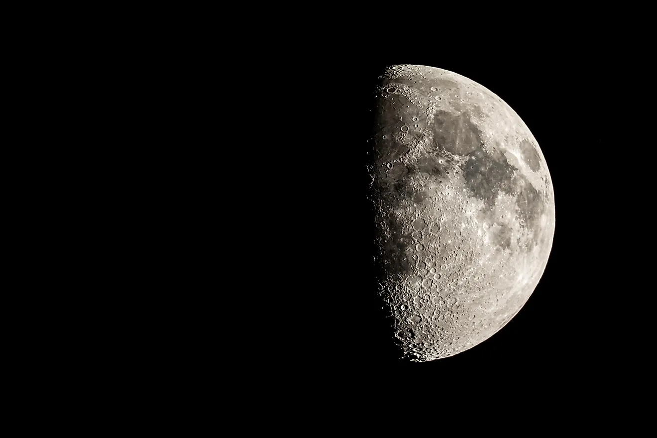 The first quarter moon reveals a hint of its "dark side."  Via Shutterstock / Jordon Sharp