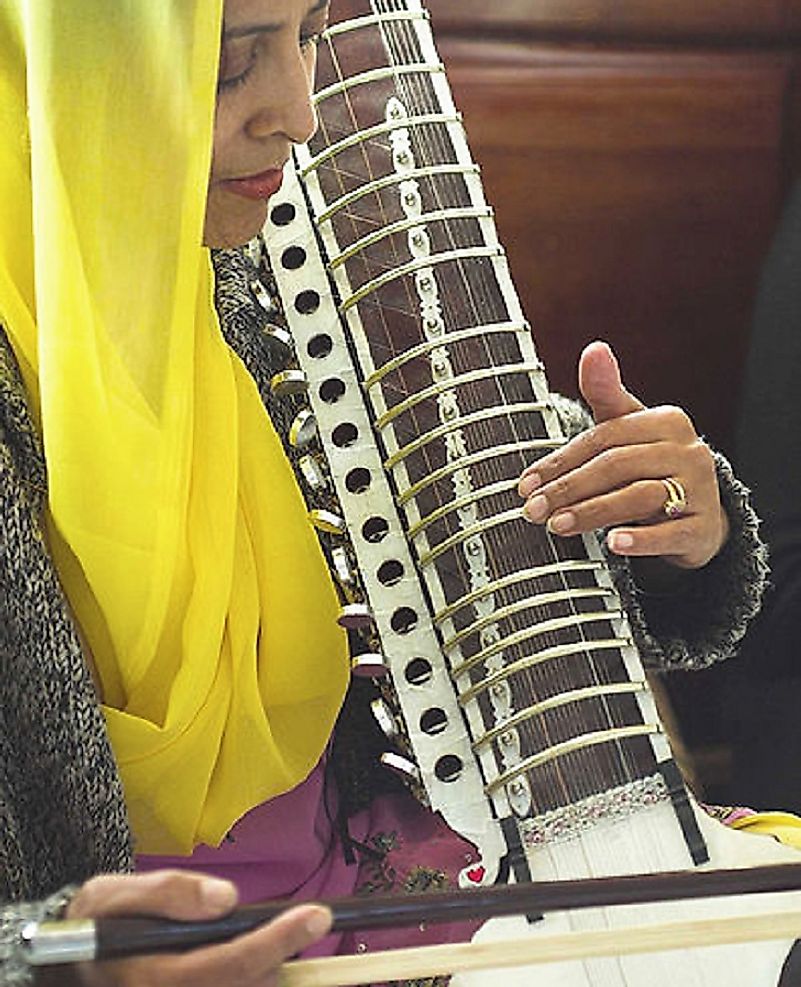A woman plays a dilruba, a traditional Punjabi folk instrument.