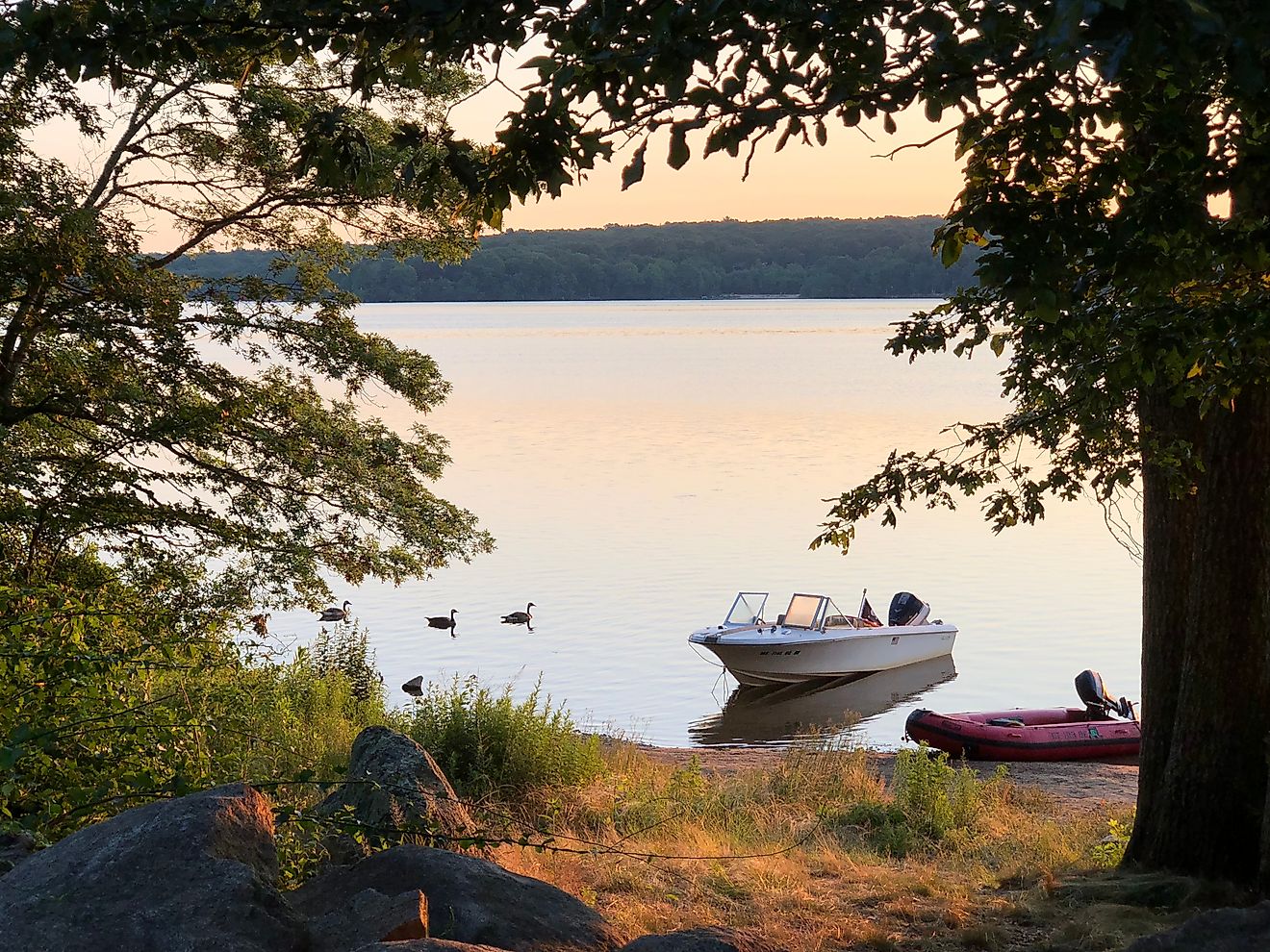 Two small boats at sunset at Watchaug Pond in Burlingame State Park, Charlestown Rhode Island 