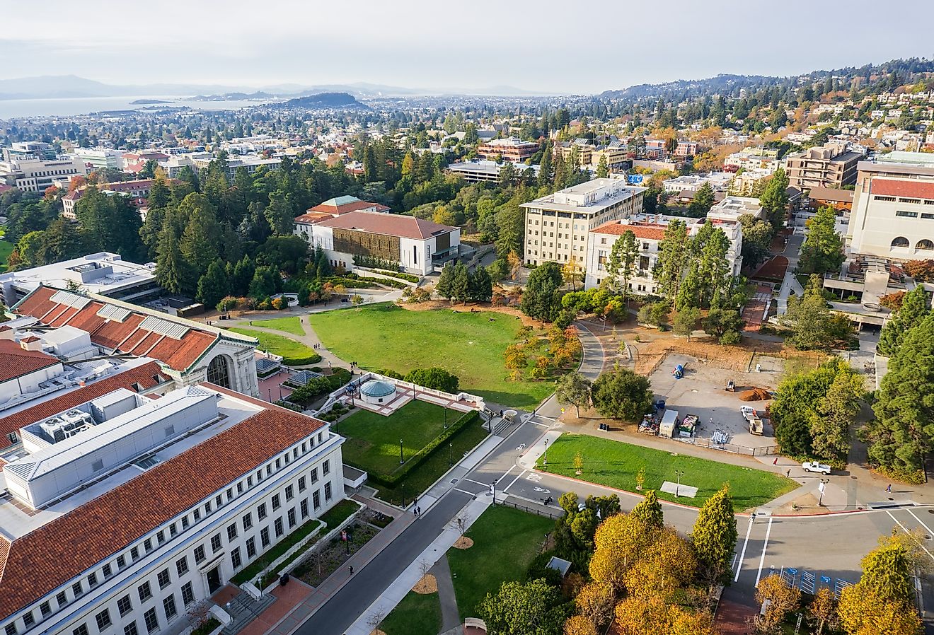Aerial view of buildings in University of California, Berkeley campus on a sunny autumn day, view towards Richmond and the San Francisco bay shoreline in the background.