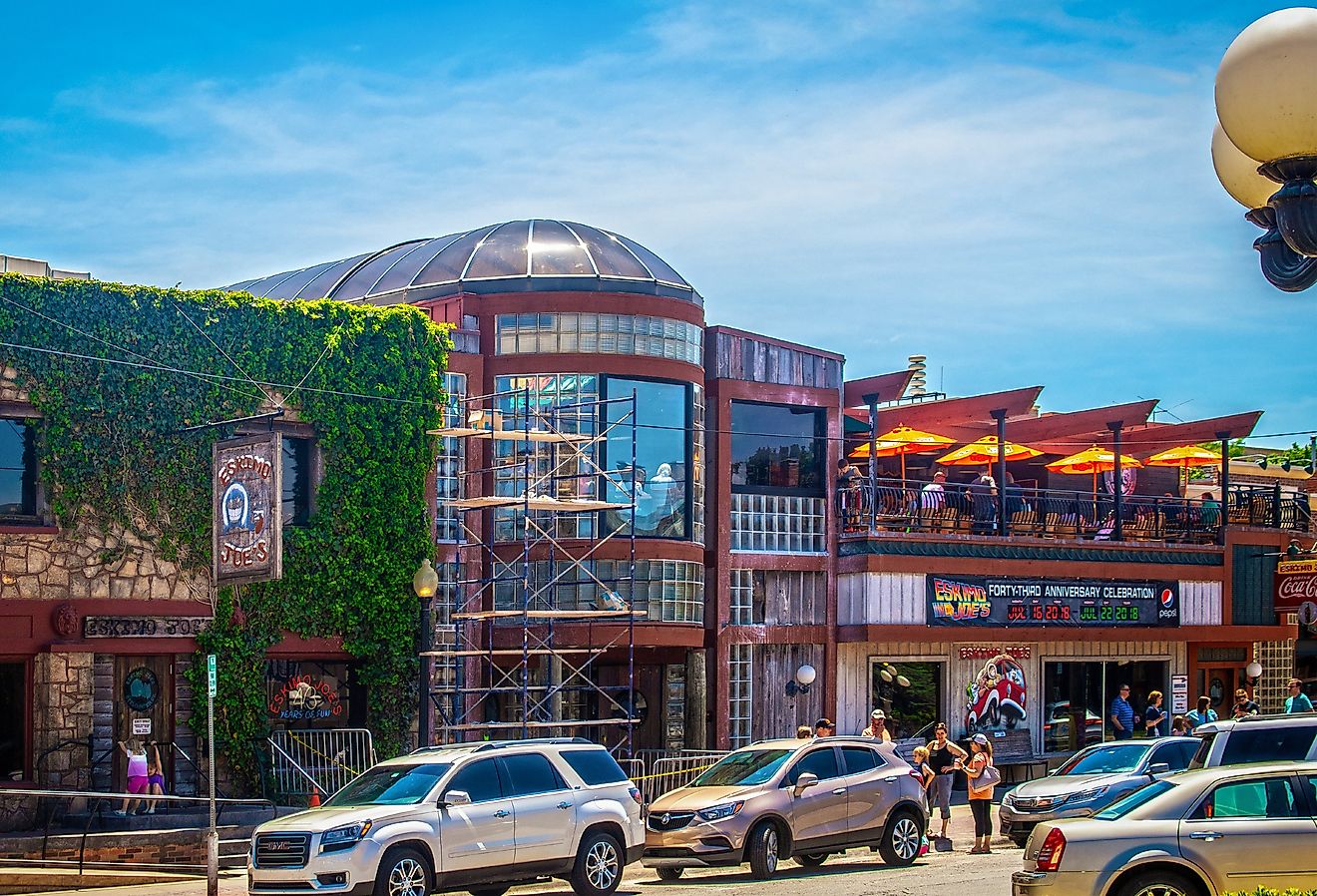 Eskimoo Joes resturant and bar under construction with people standing out front and eating on balcony near Oklahoma State University in Stillwater. Image credit Vineyard Perspective via Shutterstock