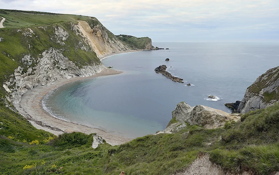 Bands of soft rocks erode faster than hard rocks, leaving a bay with headlands jutting out into the water.