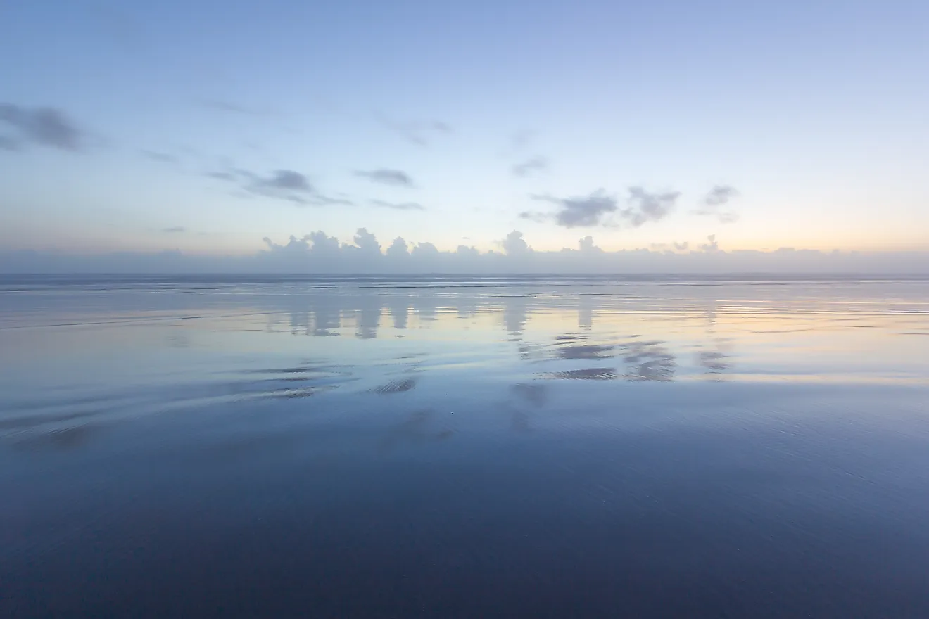 Ocean reflection of dusk sky on the beach. 