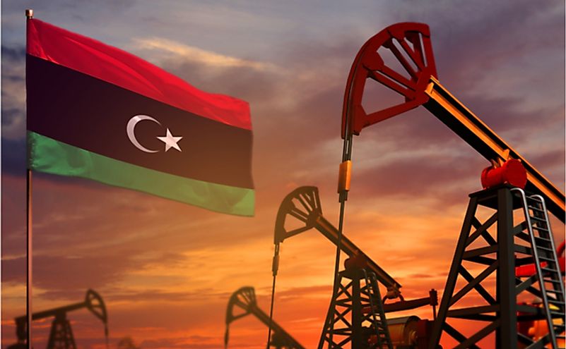  Libya flag and oil wells and the red and blue sunset or sunrise sky background.