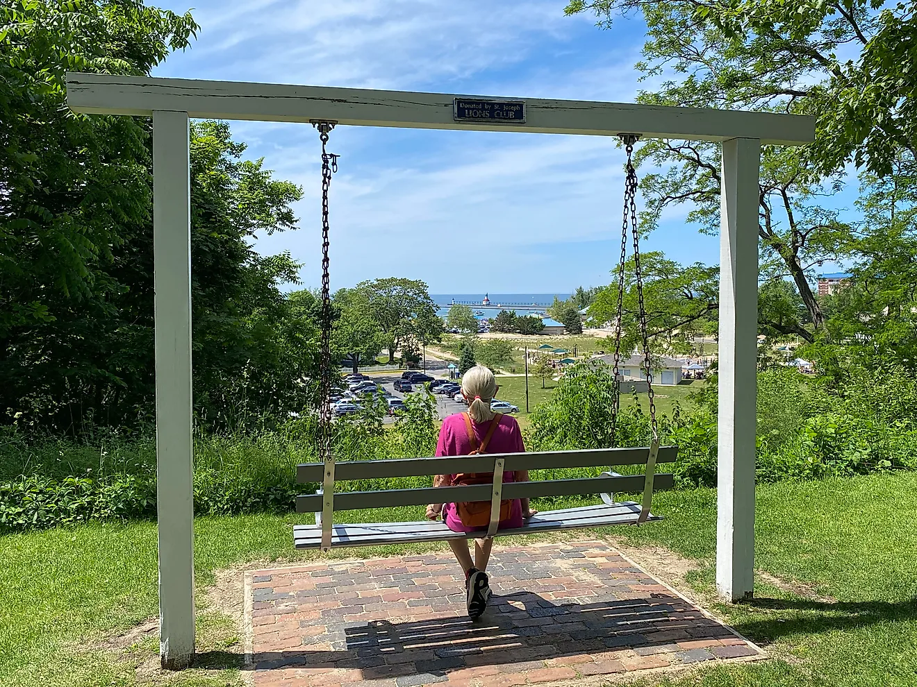 The author's mother sits peacefully on a swinging bench atop a lakeside bluff. Image credit: Andrew Douglas