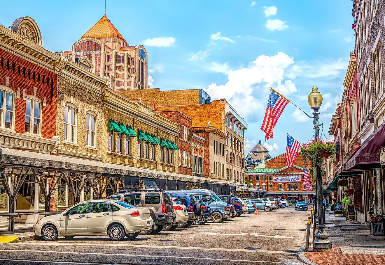 Quaint downtown main street with commercial storefront shops and flag in Roanoke, Virginia, USA.