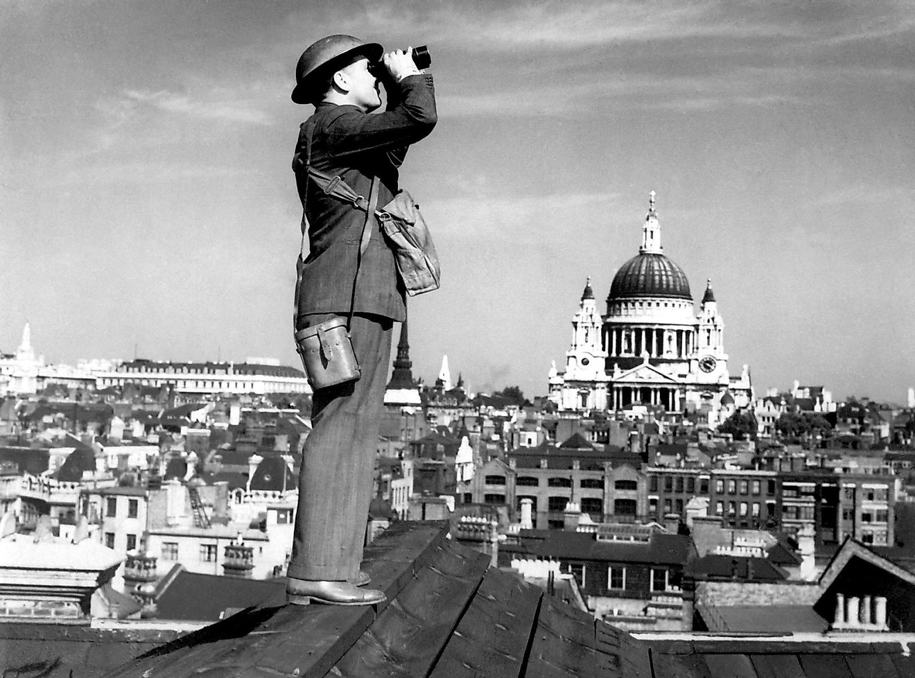 Aircraft spotter searches the sky with binoculars during the Battle of Britain. St. Paul's Cathedral is in the background. World War 2.
