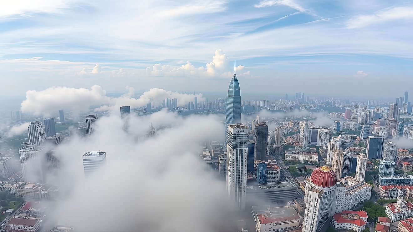 Cityscape of Chongqing at dawn with clouds covering buildings.