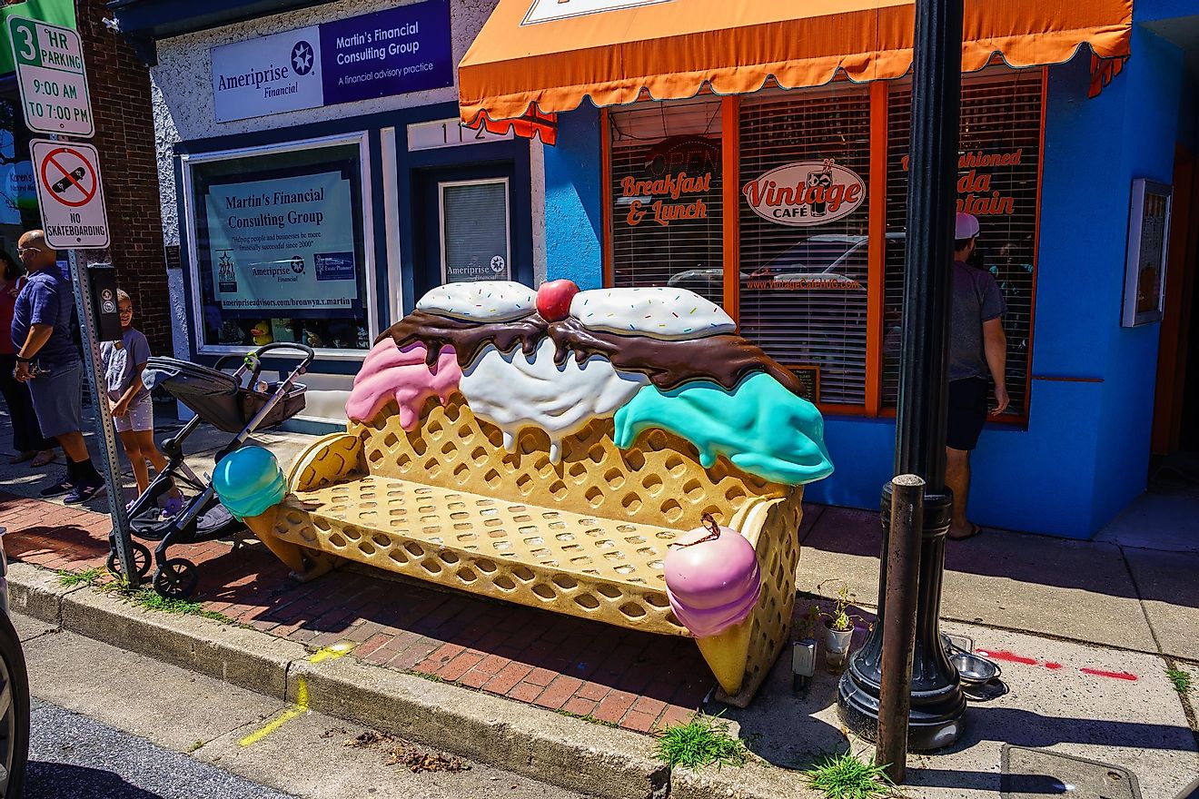 An ice cream sundae bench on the sidewalk in the business district area of the bay town.