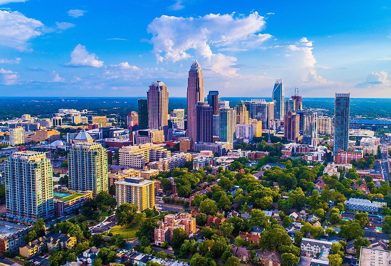 Charlotte North Carolina skyline on a bright sunny day with a few clouds in the sky.