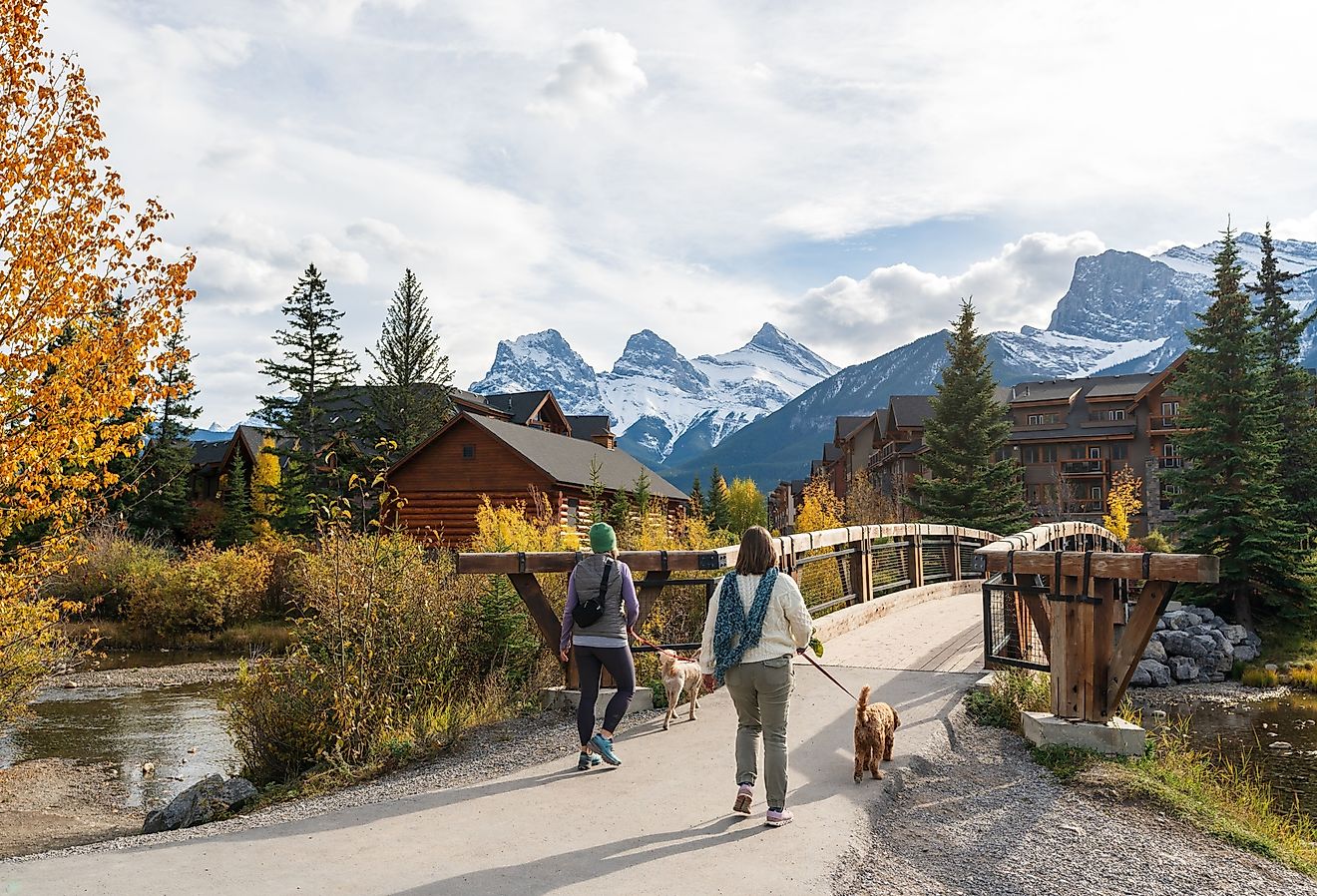 Residents walking their dogs in the town of Canmore in the fall season. Image credit Shawn.ccf via Shutterstock.