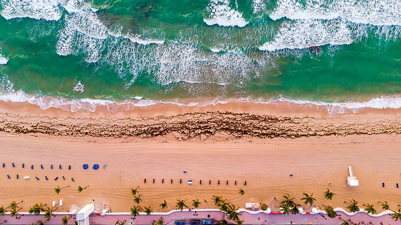 Aerial view of a coastline, Atlantic Ocean waves, and public beach at Delray Beach, Florida. 